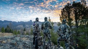 three bowhunters looking into a valley