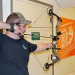 A man shooting a compound bow