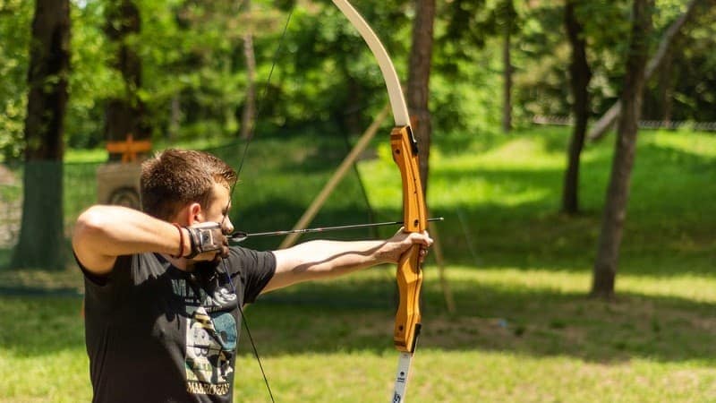 a man drawing his takedown recurve bow