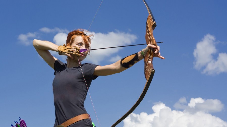 a woman aiming her recurve bow 