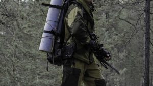 Hunter with crossbow walking with a backpack