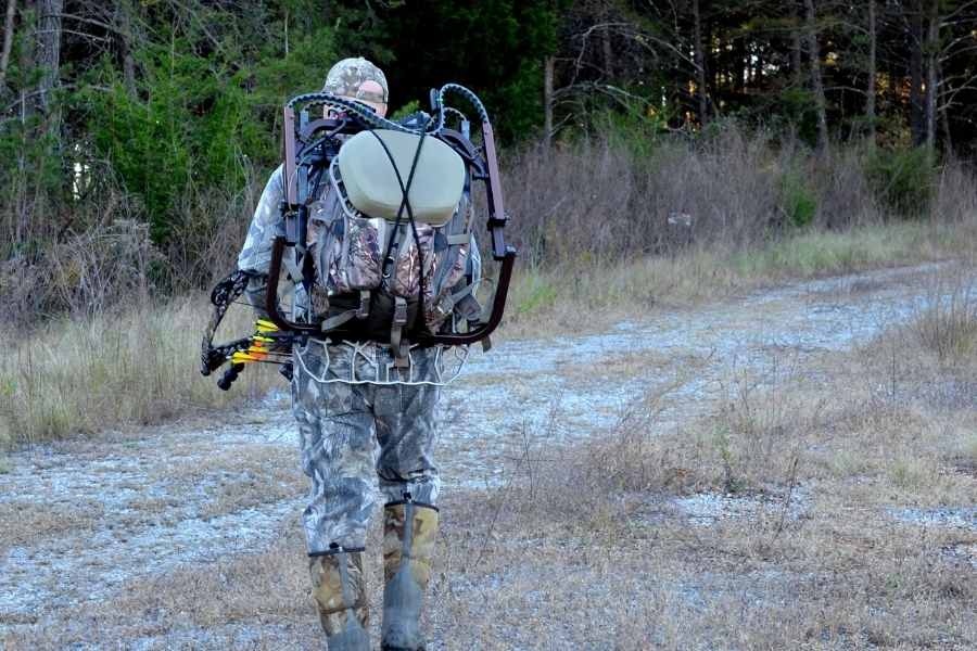 bow hunter walking in the wild with a backpack and his bow