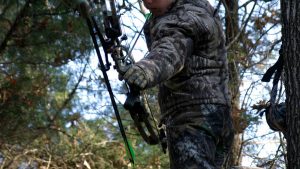 hunter in treestand aiming with bow