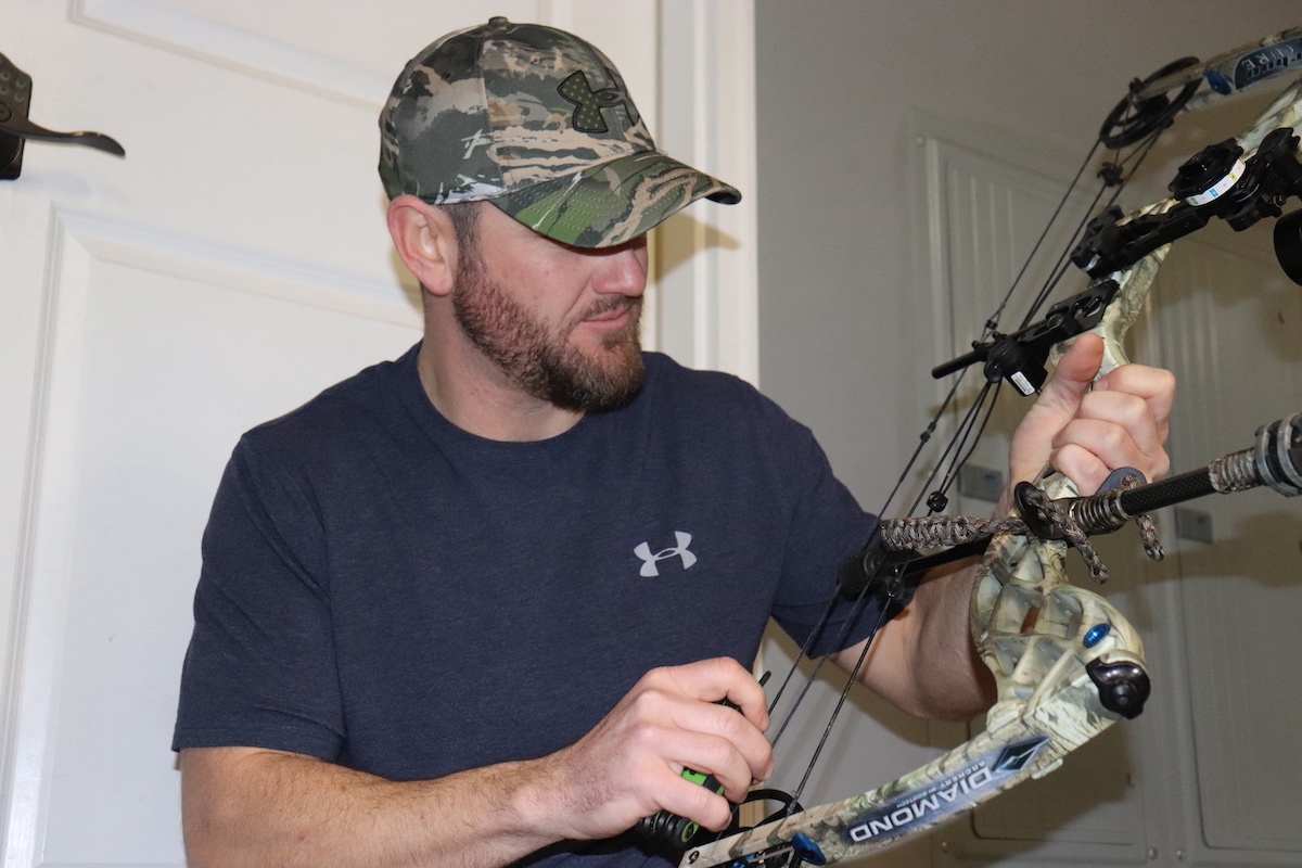 a hunter inspecting a compound bow